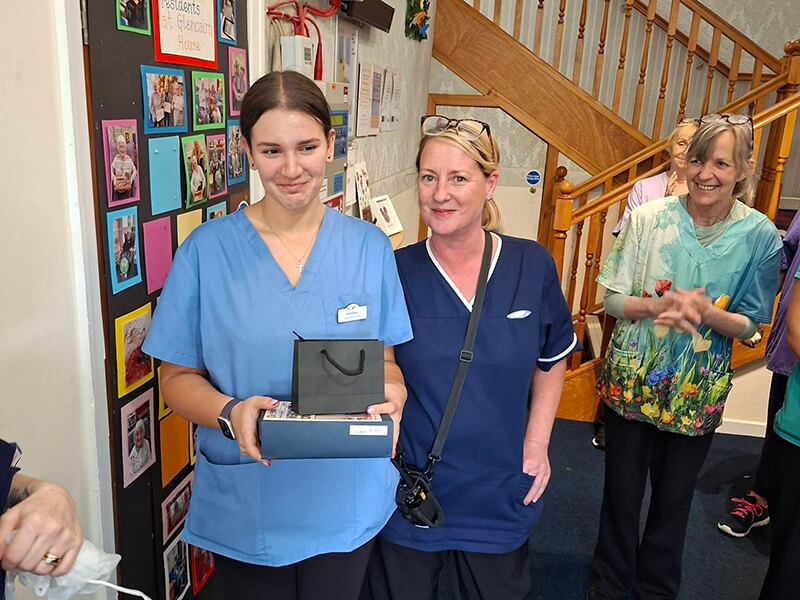 Veronika holding graduation gifts at Glencairn House after completing her college course
